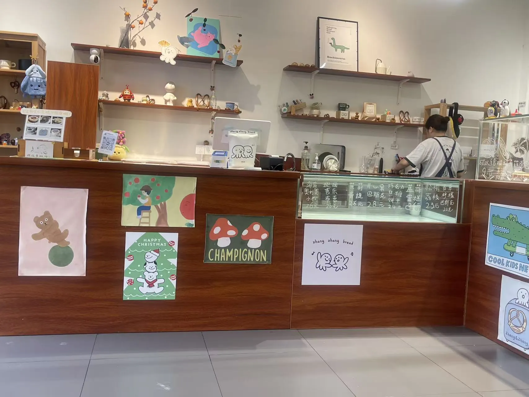 Wide view of the community bakery counter with hand-drawn posters and warm wood