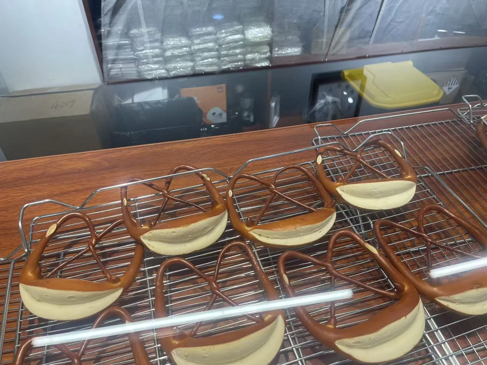 Pretzel-shaped bread displayed behind a glass bakery case