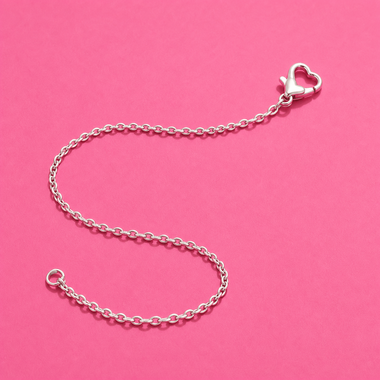 A real fine silver chain with a heart clasp on pink paper